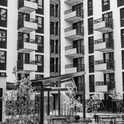 Edifício residencial contemporâneo com varandas e pátio interno, fotografado em preto e branco.