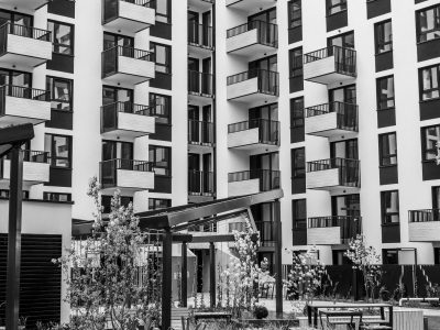 Edifício residencial contemporâneo com varandas e pátio interno, fotografado em preto e branco.