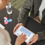 Pessoa utiliza um tablet em um posto de atendimento eleitoral durante o processo de registro.